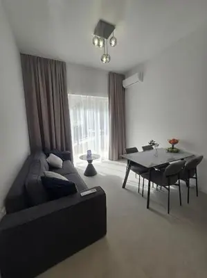 a living room with a black couch and a table at Grand Villa Deluxe Apart in Sveti Vlas