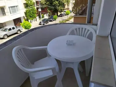 a white table and chairs on a balcony with a street at Guest house Pepina in Obzor