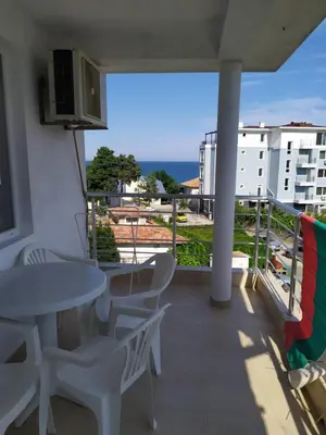 a balcony with a table and chairs and a view of the ocean at Guest house Pepina in Obzor