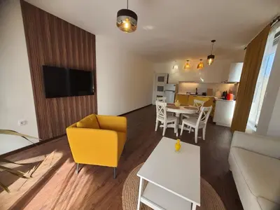 a living room with a yellow couch and a table at Вила Винсент - Villa Vincent in Lozenets
