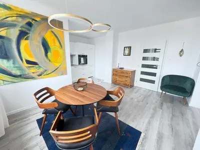 a dining room with a table and chairs and a painting at Luxus Art Apartament Burgas in Burgas City