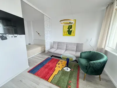 a living room with a couch and a chair at Luxus Art Apartament Burgas in Burgas City