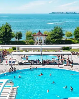 a large swimming pool with people in the water at Premier Fort Beach Sveti Vlas in Sveti Vlas