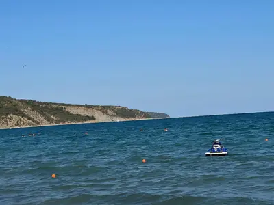 a person in a boat in the water at Fort Noks PRIVILEGE Apartment in Sveti Vlas