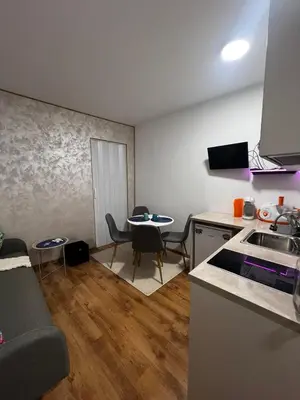 a kitchen and a living room with a table at Съни Дей ,Слънчев бряг in Burgas City