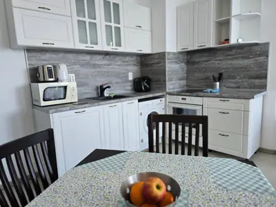 a kitchen with a table with a bowl of fruit on it at Apartament Primavera Atlantis SPA in Burgas City