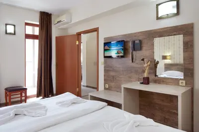 a hotel room with two beds and a mirror at Hotel Lira in Sunny Beach