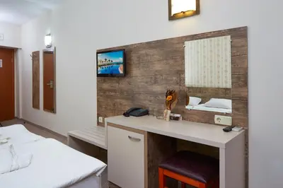 a room with a desk and a bed and a mirror at Hotel Lira in Sunny Beach