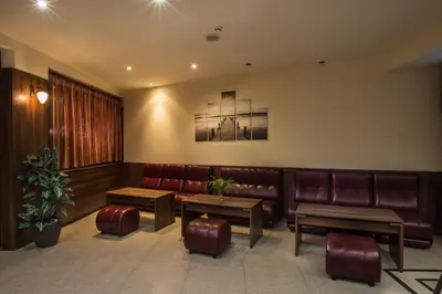a waiting room with brown leather seats and tables at Hotel Lira in Sunny Beach