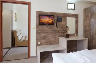 a bedroom with a bed and a mirror and a chair at Hotel Lira in Sunny Beach