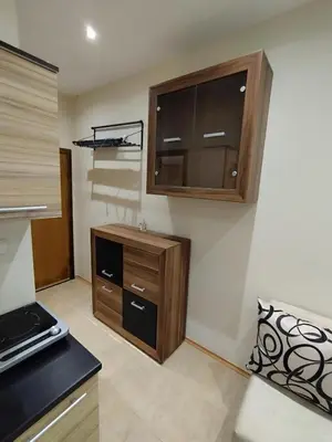 a kitchen with wooden cabinets and a counter top at Pacyfik3 in Sunny Beach