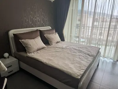a bed with white sheets and pillows in a bedroom at Lovely Studio with Sea View Grand Hotel Sveti Vlas in Sveti Vlas