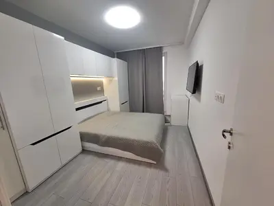 a small bedroom with a bed and a television at Central park apartment Сентрал парк апартамент Бургас in Burgas City