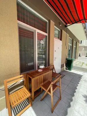 a patio with a table and two chairs and an umbrella at GALI- beach&mud therapy in Pomorie