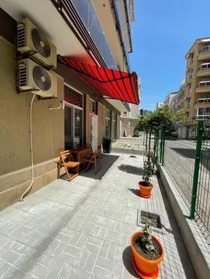 a patio with two potted plants in front of a building at GALI- beach&mud therapy in Pomorie
