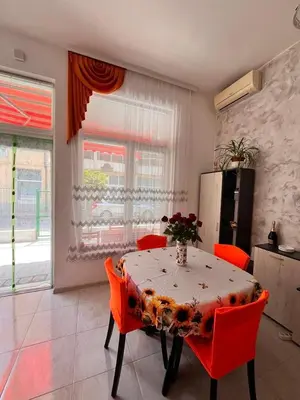 a kitchen with a table with red chairs and a refrigerator at GALI- beach&mud therapy in Pomorie