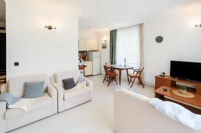 a living room with two white couches and a television at Sea Sirena with a Mountain View in Sveti Vlas