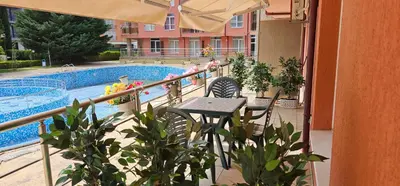 a balcony with a table and chairs next to a swimming pool at Rainbow 2 studio 7 in Sunny Beach