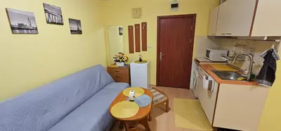 a living room with a blue couch and a kitchen at Rainbow 2 studio 7 in Sunny Beach