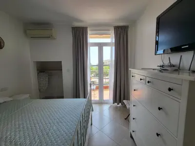 a bedroom with a bed with a flat screen tv at Solea Studio in Chernomorets