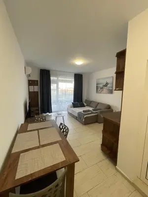 a living room with a couch and a table at Апартамент Студио Endless Созопол in Sozopol