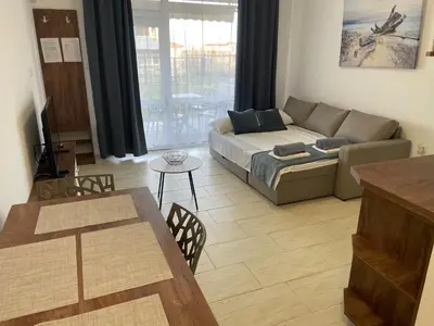a living room with a couch and a table at Апартамент Студио Endless Созопол in Sozopol