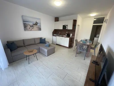a living room and kitchen with a couch and a table at Апартамент Студио Endless Созопол in Sozopol