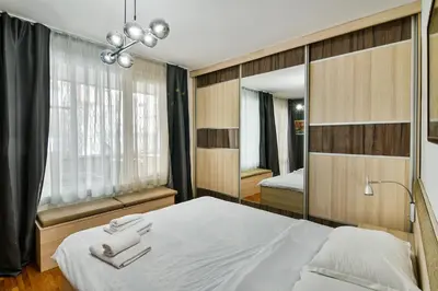 a bedroom with a white bed and a mirror at Budget Flat in Central Varna in Varna City