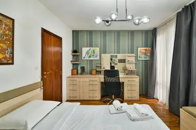 a bedroom with a bed and a desk and a chair at Budget Flat in Central Varna in Varna City