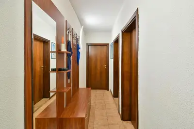 a hallway with wooden doors and a tile floor at Budget Flat in Central Varna in Varna City