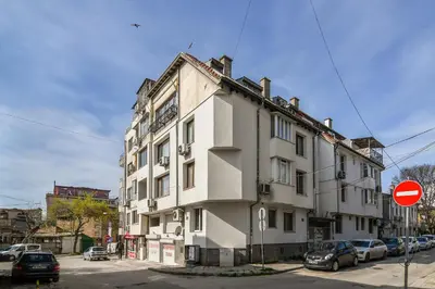 a white building with a clock on the side of it at Budget Flat in Central Varna in Varna City