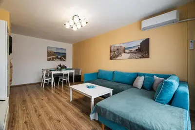 a living room with a blue couch and a table at Luxury apartment with sea view,FREE parking! in Varna City