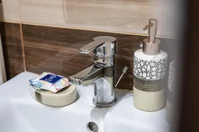 a bathroom sink with a faucet and a soap dispenser at Luxury apartment with sea view,FREE parking! in Varna City