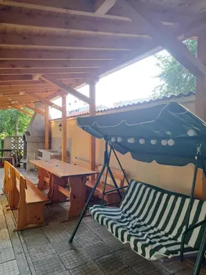 a picnic table and a bench under a roof at Rita's - family apartment by the sea in Primorsko