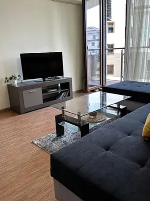 a living room with a couch and a flat screen tv at Perfect Sea and Pool View Long Beach Apartment in Shkorpilovtsi