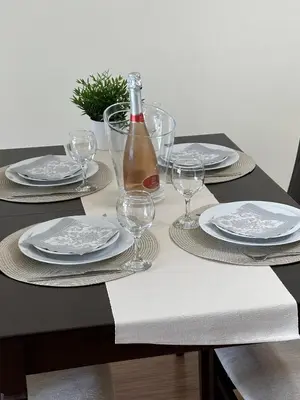 a table with plates and glasses and a bottle of wine at Perfect Sea and Pool View Long Beach Apartment in Shkorpilovtsi