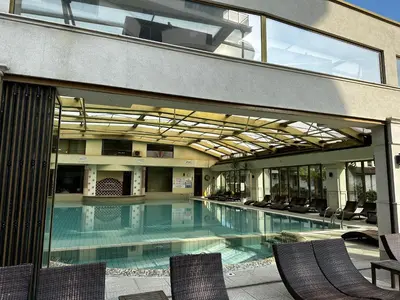 a swimming pool in a building with chairs at Perfect Sea and Pool View Long Beach Apartment in Shkorpilovtsi
