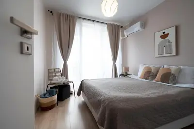a bedroom with a bed and a large window at Boho Apartment Sozopol in Sozopol
