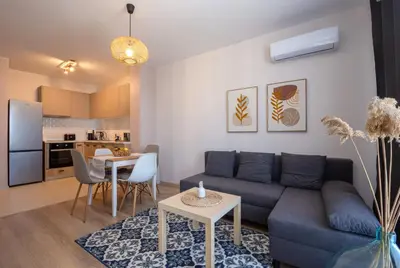 a living room with a blue couch and a table at Boho Apartment Sozopol in Sozopol