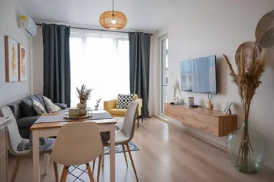 a living room with a dining table and a tv at Boho Apartment Sozopol in Sozopol