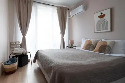 a bedroom with a large bed and a window at Boho Apartment Sozopol in Sozopol