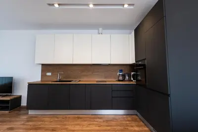 a kitchen with white cabinets and a sink at Spacious, free parking, 3min beach, Flora Panorama in Burgas City
