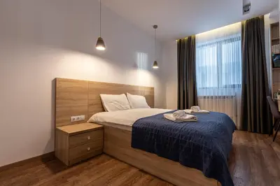 a bedroom with a large bed with a blue blanket at Spacious, free parking, 3min beach, Flora Panorama in Burgas City