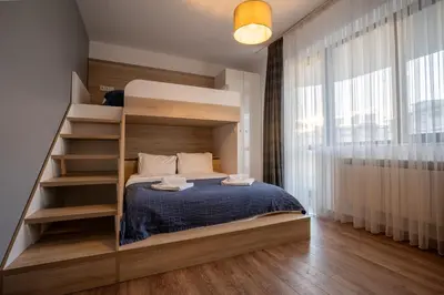 a bedroom with a bunk bed and a staircase at Spacious, free parking, 3min beach, Flora Panorama in Burgas City