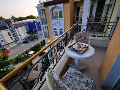a balcony with two chairs and a table on a balcony at Nemo's apartment - Sunny Beach in Sunny Beach