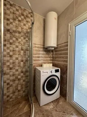 a washer and dryer in a bathroom with a window at Nemo's apartment - Sunny Beach in Sunny Beach