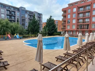 a pool with chairs and umbrellas next to some buildings at Rainbow 2 studio 40 in Sunny Beach