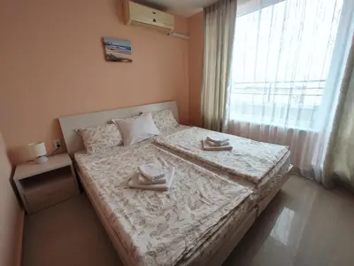 a bedroom with a bed with two towels on it at Double Peach Apartment in Sveti Vlas