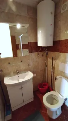 a bathroom with a sink and a toilet and a mirror at Double Peach Apartment in Sveti Vlas