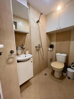 a bathroom with a shower and a toilet and a sink at Cozy One-Bedroom Apartment near Burgas Sea Garden in Burgas City